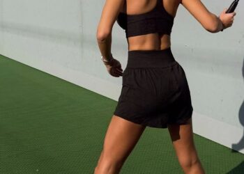 Christine McGuinness prikazuje svoju toniranu figuru u crnom sportskom grudnjaku i kratkim hlačama dok uživa u igri tenisa u isječku za vježbanje.