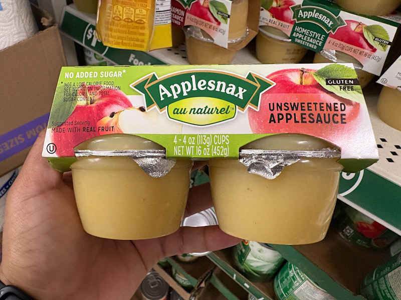 Netko drži paket umaka od jabuka.