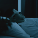 Sleepmaxxing trend: žena spava u mračnoj spavaćoj sobi sa svilenom maskom za oči